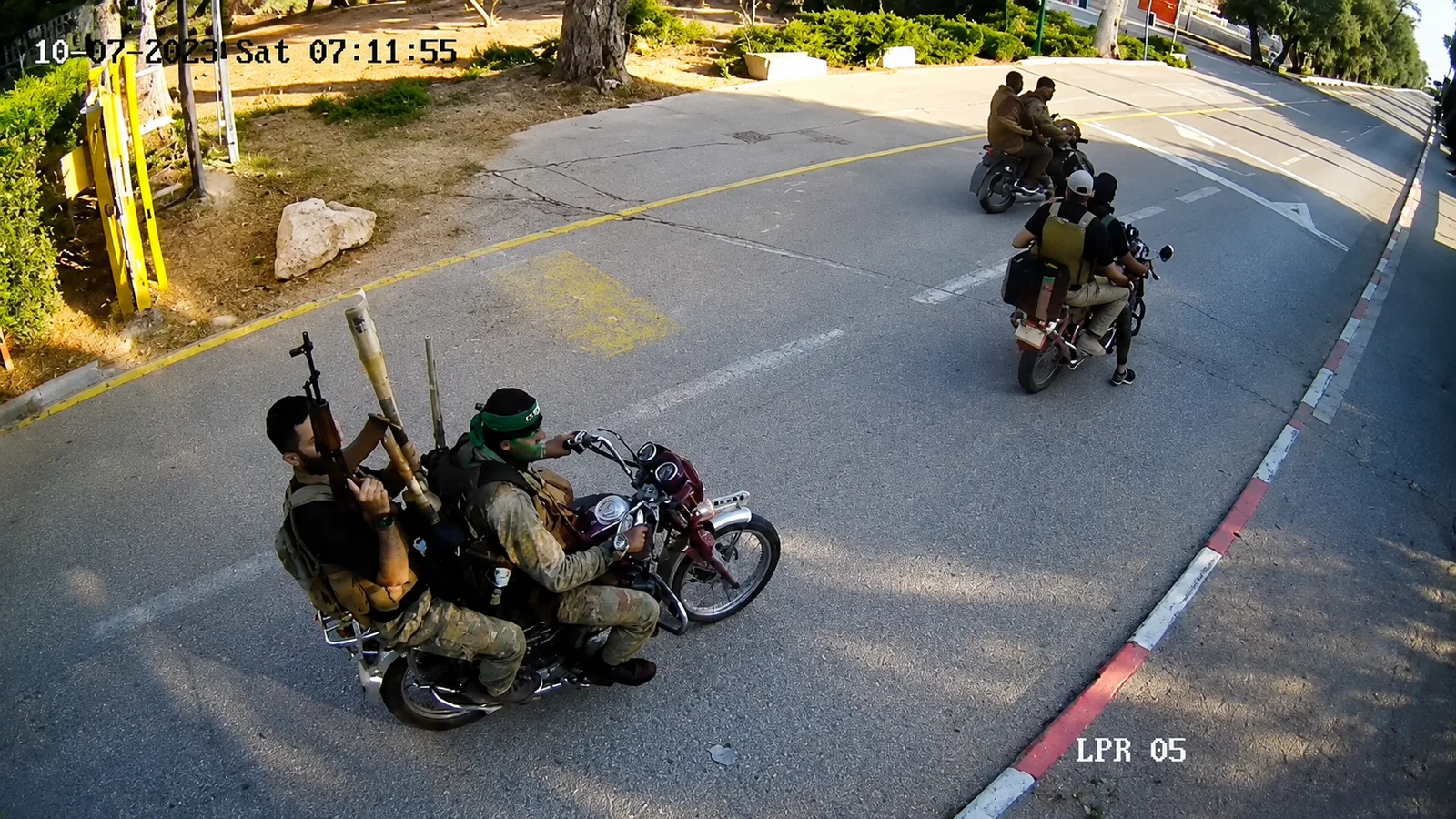 Una cámara de seguridad registra a hombres en motocicletas por una calle.
